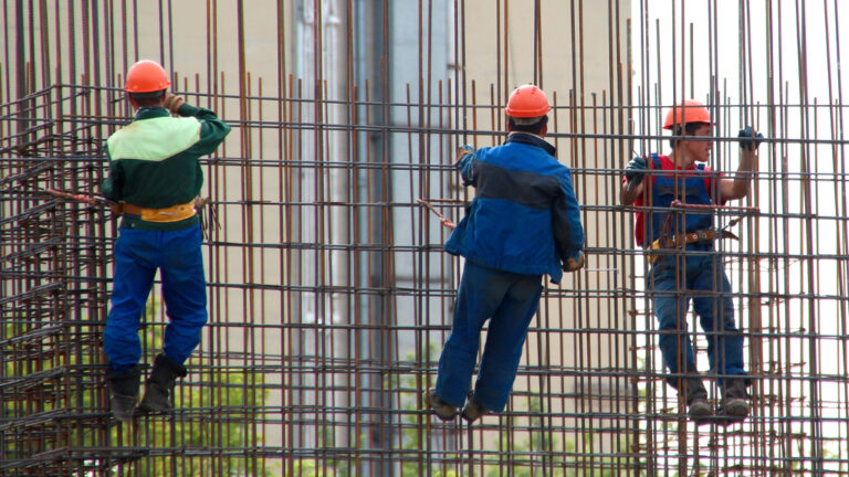 Treballadors de la construcció penjats en uns ferros