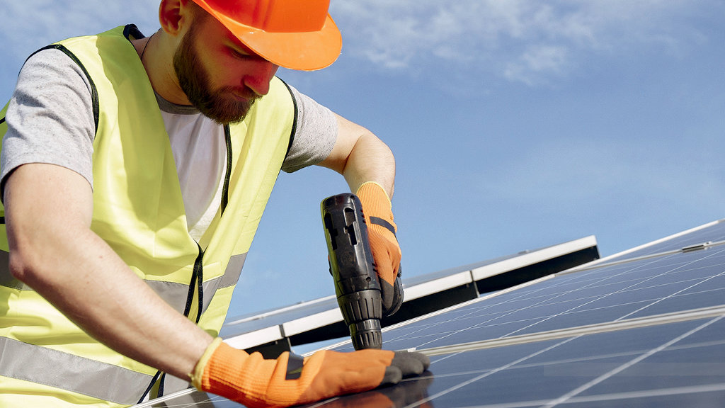 Treballador assegurant unes plaques solars