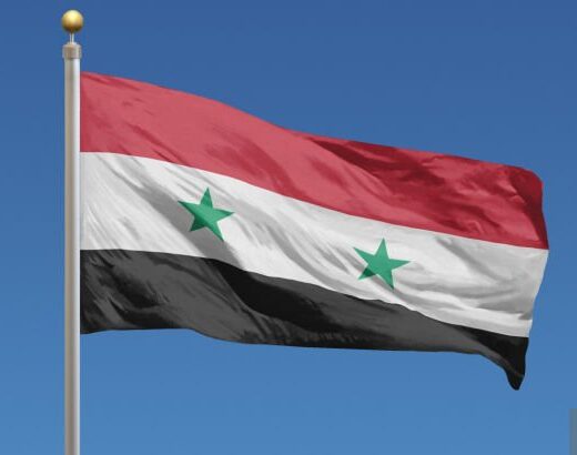 Flag Of Syria In Front Of A Clear Blue Sky